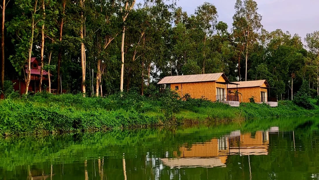 Bamboo cottages reflected in the resort lake